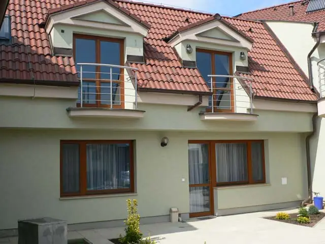 Rodinný dom s drevenými oknami a balkónovými dverami
